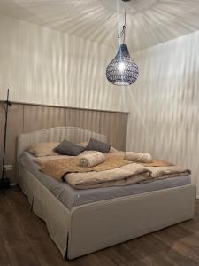 a bed in a bedroom with a pendant light at Farska apartman priamo v centre Nitry in Nitra