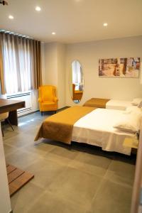 een slaapkamer met een bed, een bureau en een spiegel bij La Corte Park Hotel & Spa in Palma Campania