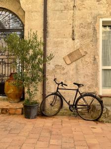 een fiets geparkeerd tegen een muur naast een plant bij Corte Oliveta in Matera