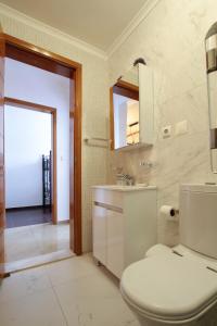 a bathroom with a toilet and a sink and a mirror at Josden Maianga T2 in Luanda