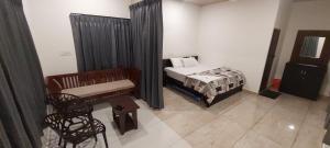 ein kleines Schlafzimmer mit einem Bett und einem Stuhl in der Unterkunft Hill valley farm resort in Viripara