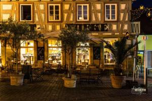 a building with tables and chairs and trees in front of it at Apartment am Schlosshof in Besigheim