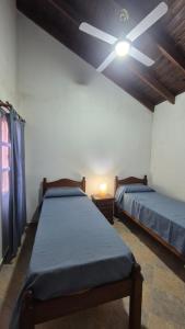 una camera da letto con due letti e un ventilatore a soffitto di Ayres de Colon a Colón