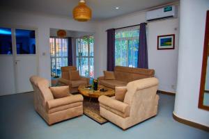 ザンジバルシティにあるMbweni Apartmentのリビングルーム(ソファチェア、テーブル付)
