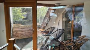 un balcone con sedie e un tavolo di vetro su una veranda di Spacious 4-Bedroom LOFT a Katzbach Altre 11 foto