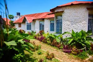 ザンジバルシティにあるMbweni Apartmentの赤い屋根の古い石造りの家