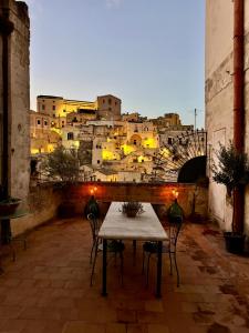 een tafel en stoelen met uitzicht op de stad bij Corte Oliveta in Matera