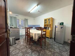 a kitchen with a table and chairs and a refrigerator at Calm Nest Apartment in Flic-en-Flac