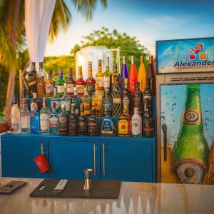 uma exposição de garrafas de bebidas alcoólicas em um armário azul em Harmonia - Sunbeha resort, Juan Dolio em Juan Dolio