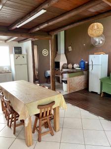 Chalé Suites Maresias في ساو سيباستياو: مطبخ مع طاولة مع كراسي وثلاجة
