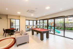 a living room with a ping pong table and a playground at Studio Resort Piscina Aquecida GYM Bem localizado in Curitiba