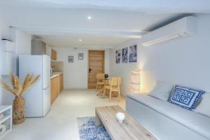 Una sala de estar blanca con un sofá y una mesa. en Eros Suite, Greek-style apartment with Jacuzzi, en Brignoles