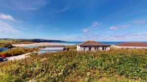 a house on a hill with the ocean in the background at C16 Treverbyn, Riviere Towans in Hayle