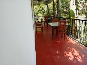 a balcony with a table and chairs on it at Camellia Guest Inn in Ella