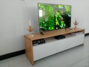 a flat screen tv on a wooden stand with a fish tank at LOMS Furnished Apartment - Luxurious Modern House near KKI Airport in Kenneth Kaunda International Airport