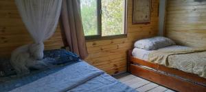 a bedroom with two beds in a log cabin at Casa Iris del monte in La Pedrera