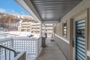 a balcony with a view of a snow covered mountain at Hameau 26-43 Studio in Stoneham