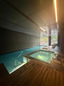 a large swimming pool in a building with a wooden floor at Cozy and Comfortable 2BR Apartment with master Ensuite and bathrooms in Melbourne