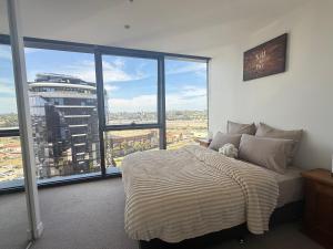 a bedroom with a bed and a large window at Cozy and Comfortable 2BR Apartment with master Ensuite and bathrooms in Melbourne +24 photos