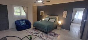 クルーフにあるUkosi Brisaのベッドルーム1室(ベッド1台、青い椅子付)