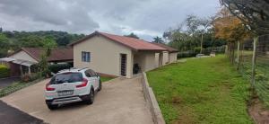 een auto geparkeerd voor een wit huis bij Ukosi Brisa in Kloof