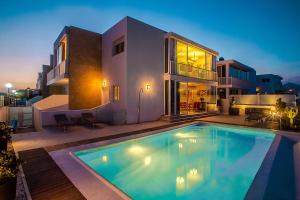 eine Villa mit einem Pool vor einem Haus in der Unterkunft Alexia Beach in Playa Honda
