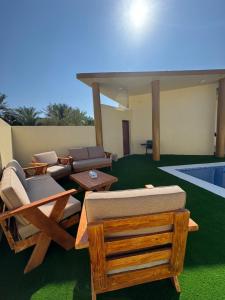 a living room with chairs and a swimming pool at Ebreez Heaven in Wāsiţ