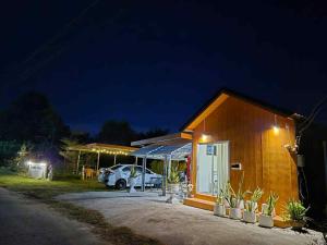 Alisa Villa, Ubon Cottage في Ban Pla Duk: منزل صغير ليلاً مع سيارة متوقفة