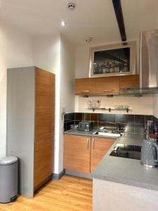 a kitchen with wooden cabinets and a counter top at Stylish City Loft Getaway in Nottingham