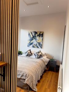 a bedroom with a bed and a painting on the wall at Stylish City Loft Getaway in Nottingham