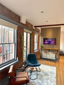 a living room with a brick wall and a blue chair at Stylish City Loft Getaway in Nottingham