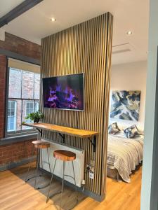 a bedroom with a bed and a desk and stools at Stylish City Loft Getaway in Nottingham +4 photos