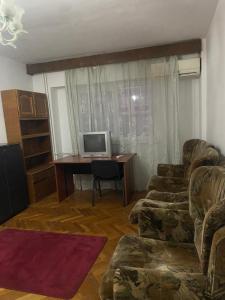 een woonkamer met een bank en een bureau bij Apartament cu 2 camere decomandat in Craiova