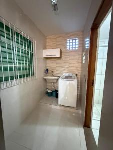 een kleine badkamer met een toilet en een raam bij Casa Praia Bertioga in Bertioga