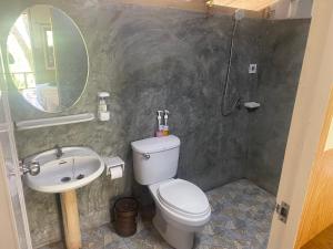 a bathroom with a toilet and a sink and a mirror at Mook Happy Bungalow in Ko Mook +12 photos