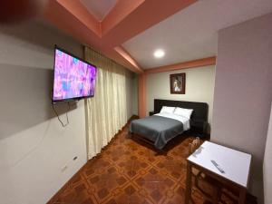 タクナにあるHostal Williamsのベッドと薄型テレビがあるホテルの部屋 +4枚の写真