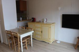 a kitchen with a table and a yellow cabinet and a tv at Appartement Peyragudes les Agudes in Gouaux-de-Larboust