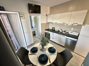 a kitchen with a table with chairs and a sink at Apartmani Zaliv in Tivat