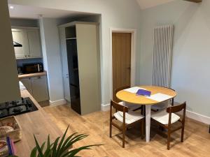 a kitchen with a table and chairs in a room at Country Cottage with moat in Ingatestone +13 photos