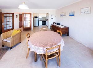 a dining room with a table and chairs and a kitchen at Bien-être & Panorama - Les Gîtes de la Côte d'Amour in Le Croisic