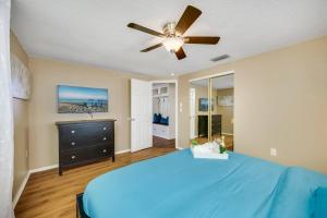 a bedroom with a blue bed and a ceiling fan at Beautiful & Cozy Home on a Canal in Hudson, FL! in Hudson