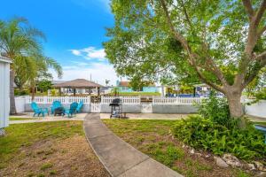 a park with blue chairs and a tree at Beautiful & Cozy Home on a Canal in Hudson, FL! in Hudson