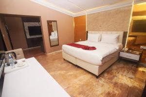 Una habitación de hotel con una cama grande y una mesa. en Chateux de atlantique Hotel, en Lagos