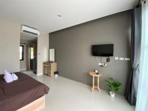 เขาค้อคริสตัลวิว,Khao kho Crystal View في Ban Huai Phai: غرفة نوم مع سرير وتلفزيون بشاشة مسطحة