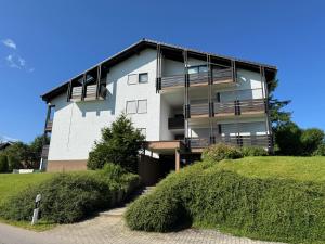 a white building with balconies on the side of it at Ferienwohnung Sunnabichi in Wertach