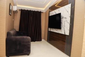 Una sala de estar con un televisor y una silla. en Chateux de atlantique Hotel, en Lagos 12 fotos más