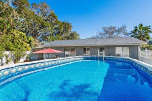 a large blue swimming pool in front of a house at Gorgeous Heated Pool House Near Gulf Beaches! in Cross Bayou