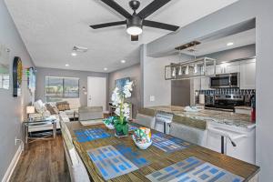 a kitchen and living room with a table and a ceiling fan at Gorgeous Heated Pool House Near Gulf Beaches! in Cross Bayou