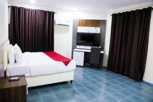 Habitación de hotel con cama y escritorio. en Chateux de atlantique Hotel, en Lagos