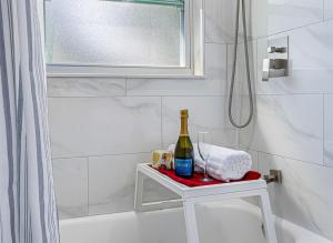 Un baño blanco con una botella de champán y una ducha. en Charming & Renovated Home 20 Minutes from Tampa, en Brandon 57 fotos más
